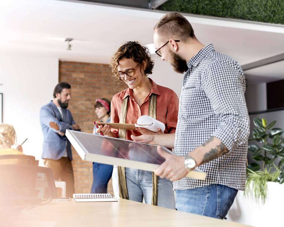 First Step Ein Team von Menschen arbeitet in einem Büro, einige verwenden Laptops.